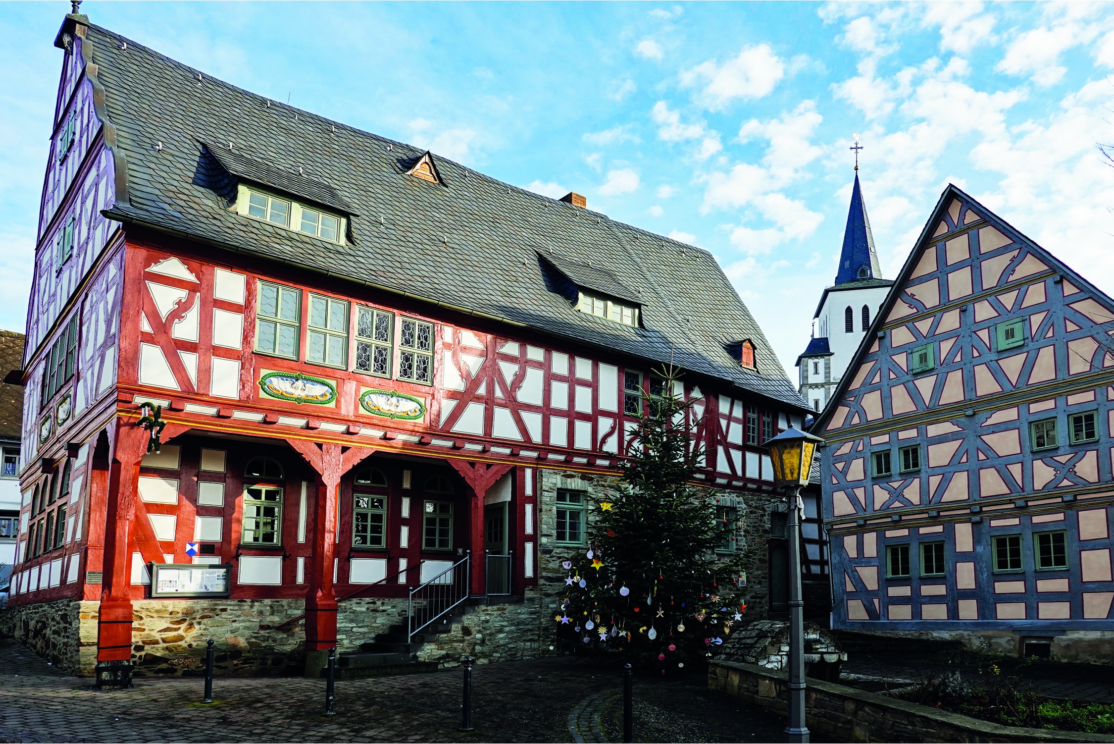 Das Rathaus in Niederbrechen mit dem Kirchturm von St. Maximin
